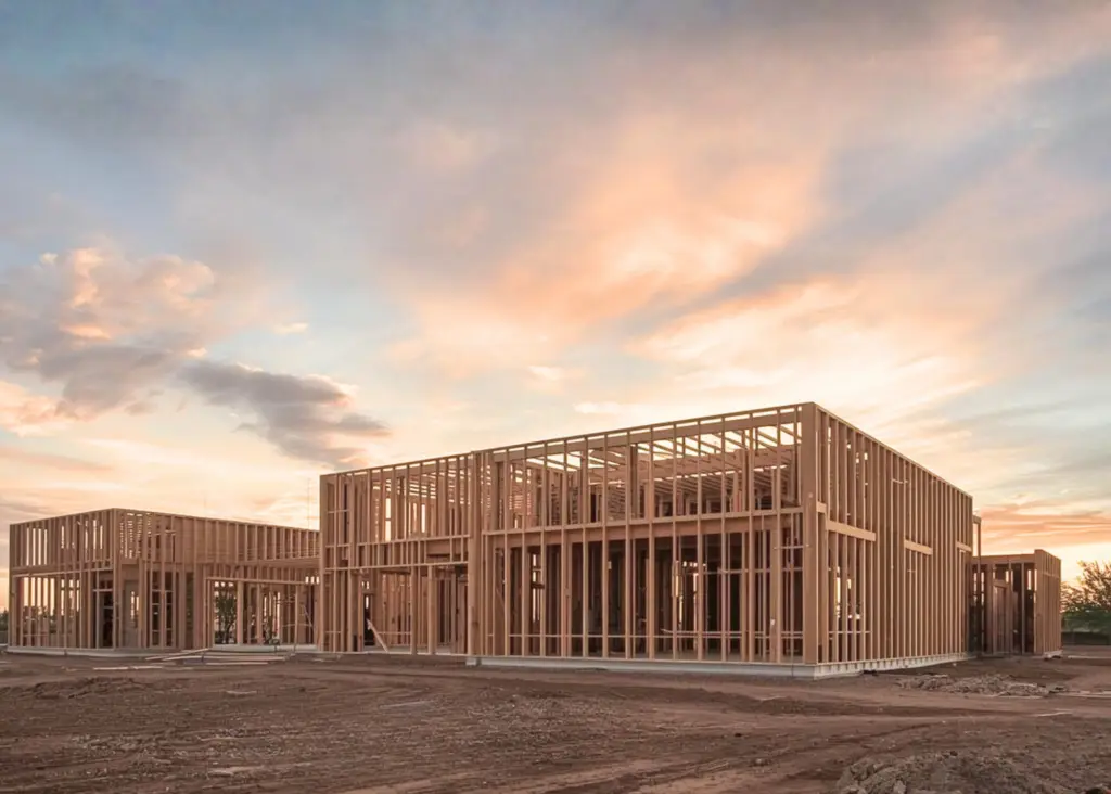 Illustrative view of timber house framing at sunset.