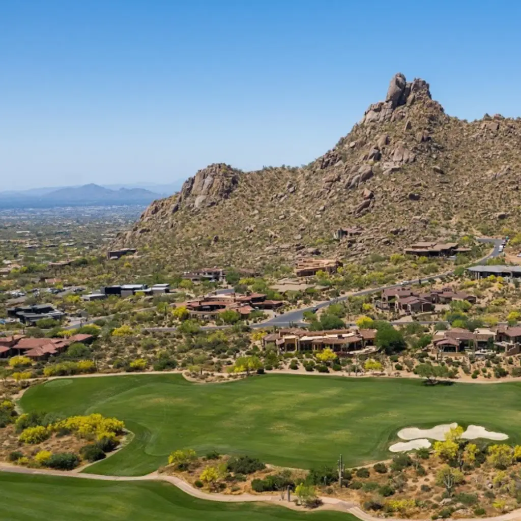 Desert golf course below a prominent rocky peak.